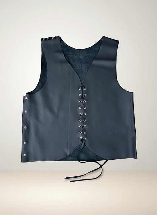 Chaleco Pampa Boho de piel negro artesanal con cordones dorados y remaches. Sin mangas, ideal para capas.