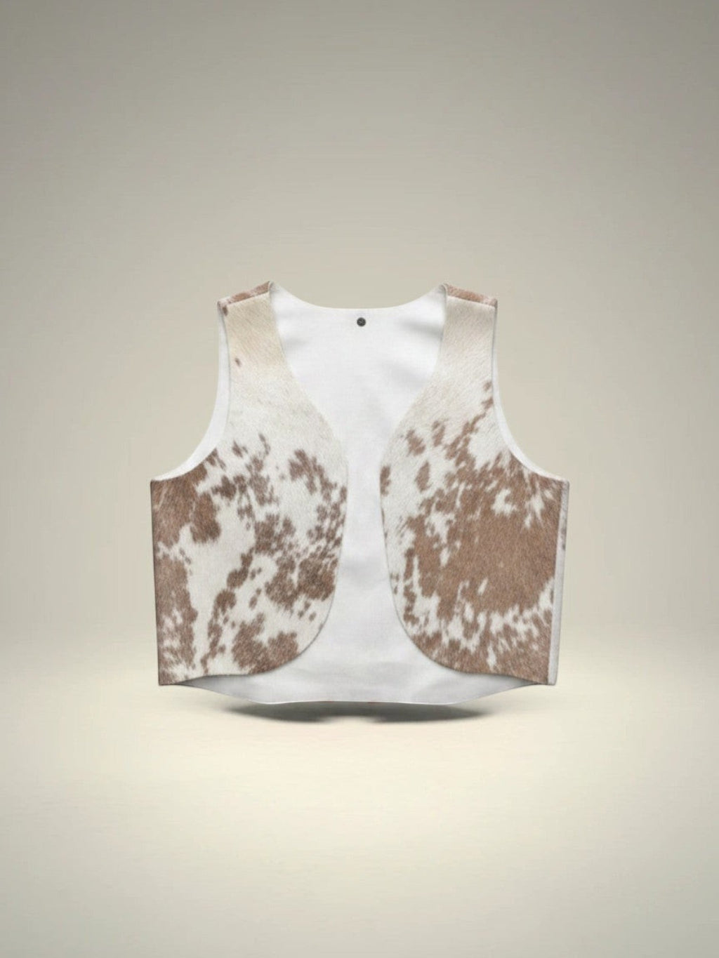Chaleco Pampa Boho de piel de vaca con estampado moteado en blanco y marrón, sin mangas y abierto por delante. Unitalla.