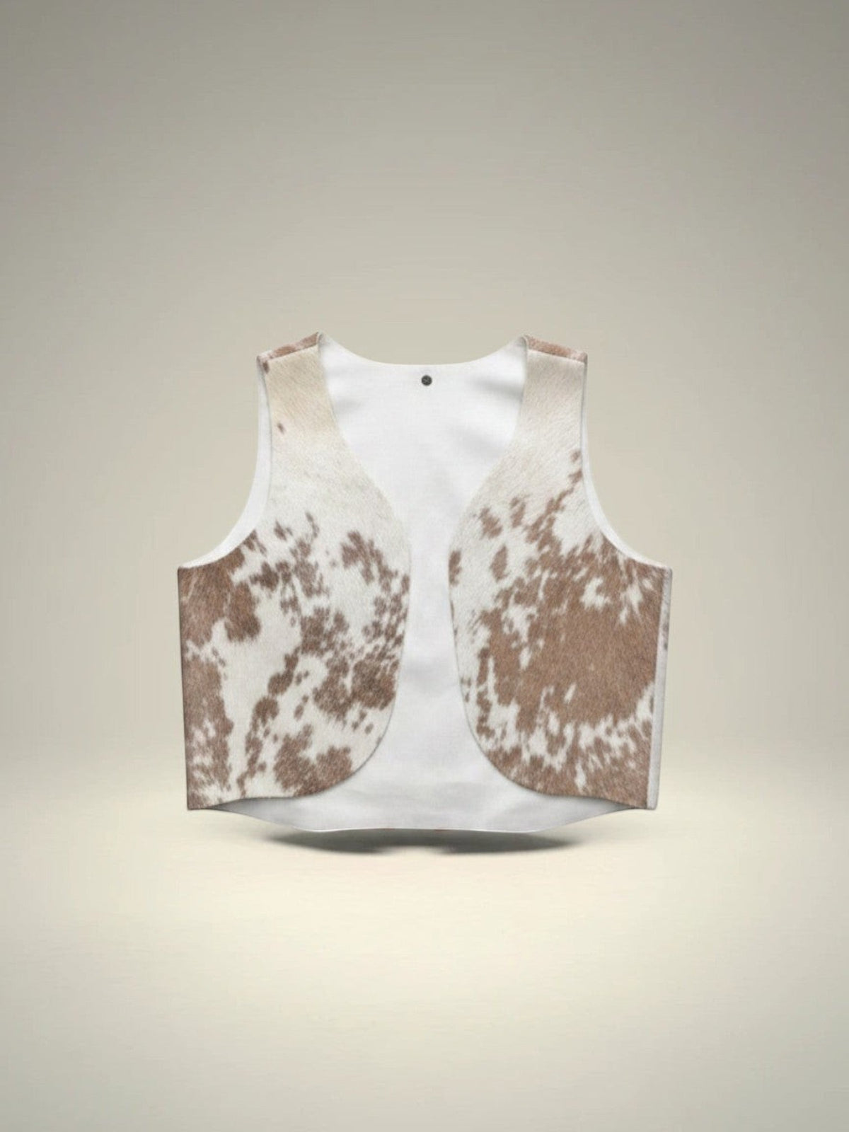 Chaleco Pampa Boho de piel de vaca con estampado moteado en blanco y marrón, sin mangas y abierto por delante. Unitalla.