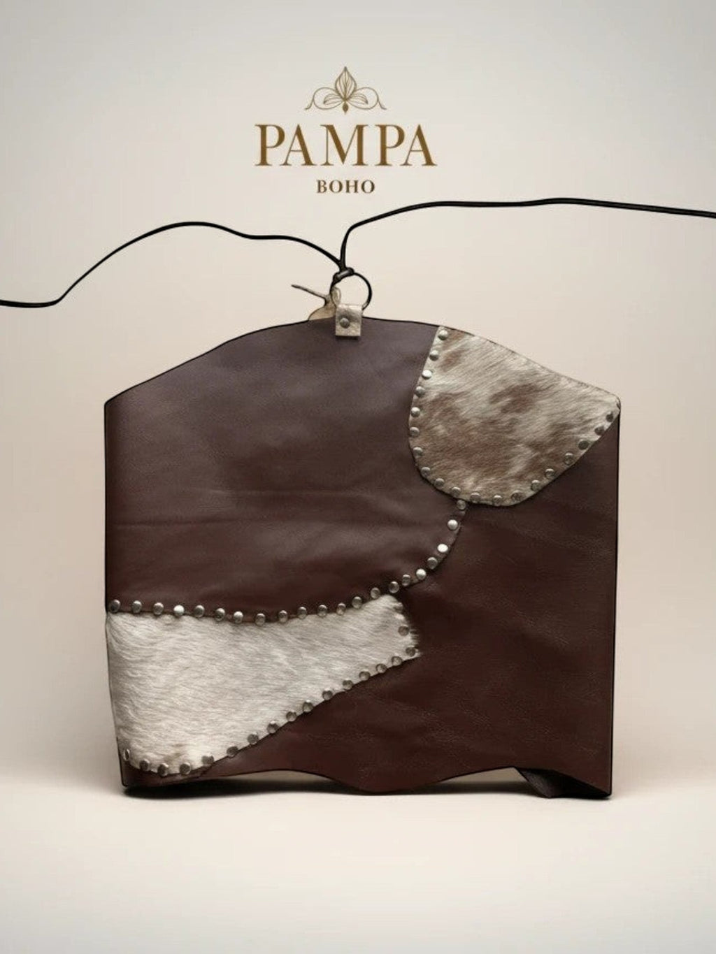 Top Pampa Boho de piel marrón con detalles de pelo de vaca y remaches, diseño halter abierto en la espalda.